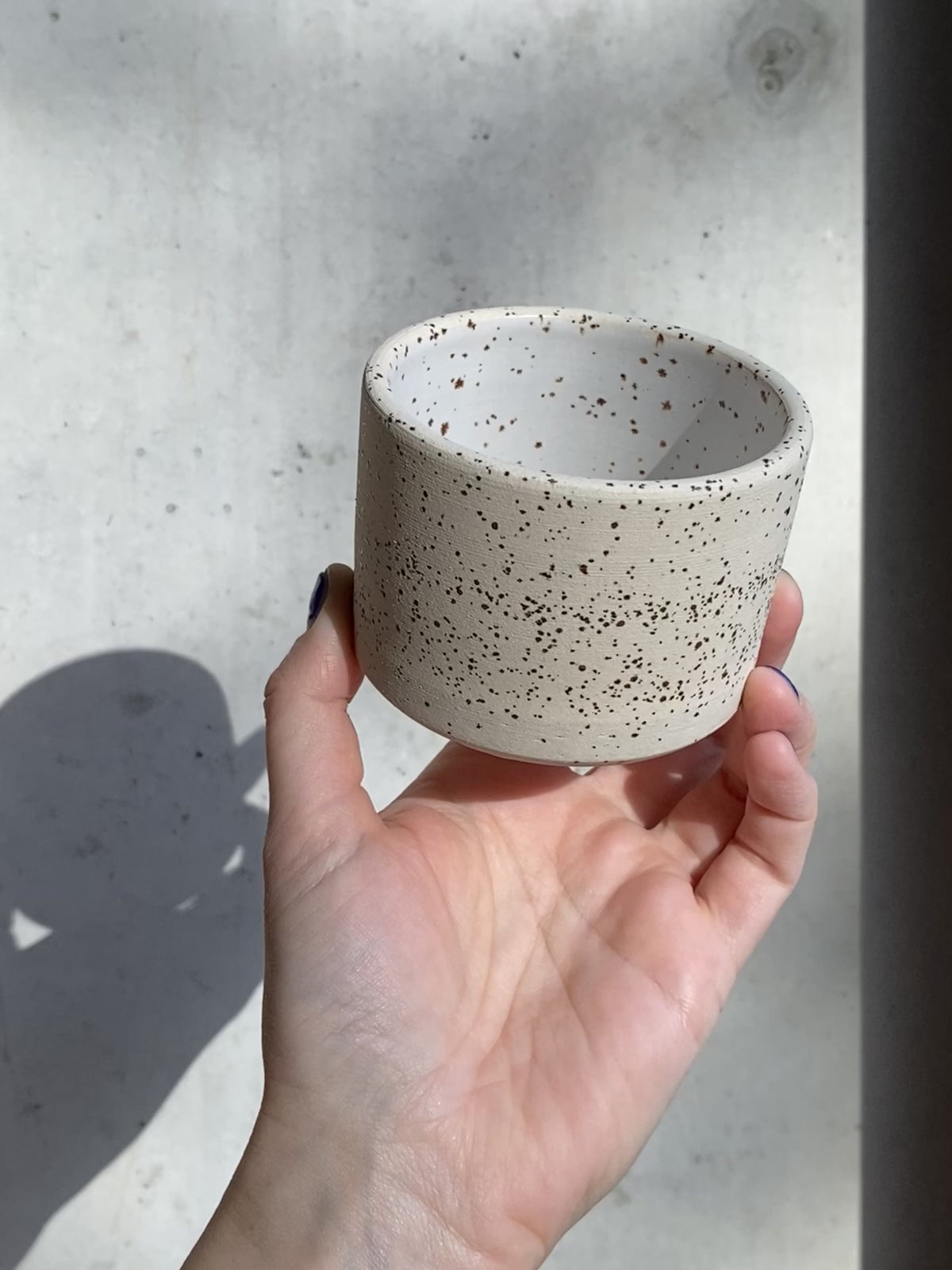 handgedrehter Becher aus Ton mit Spots in weiss matt