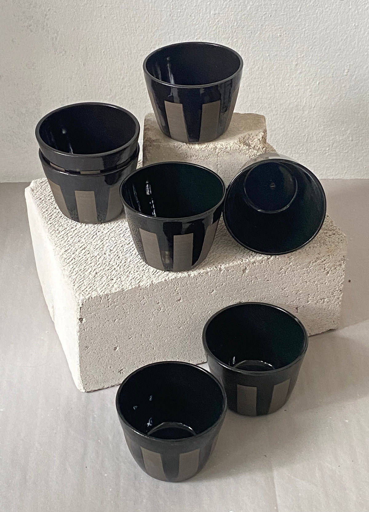 Keramik Becher aus grauem Ton mit schwarz glänzenden Streifen