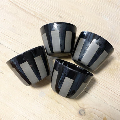 Keramik Becher aus grauem Ton mit schwarz glänzenden Streifen